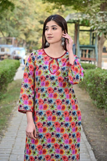 Woman wearing a colorful floral dress in an outdoor setting