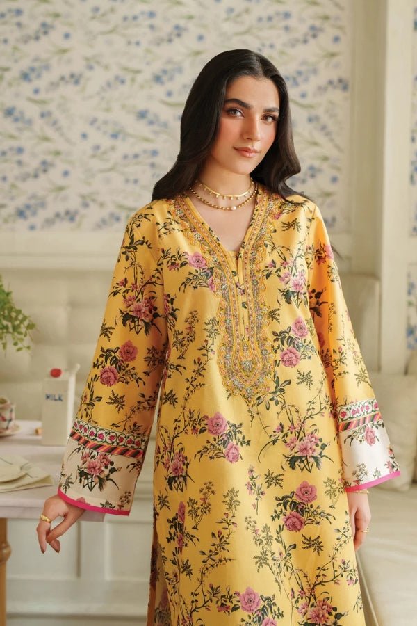 Woman wearing a yellow floral dress in a decorated room.