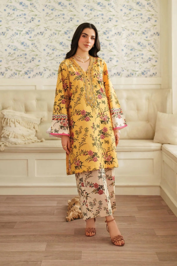 Woman wearing a yellow floral outfit in a decorated room.