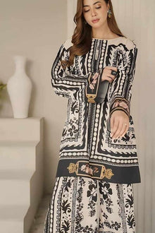 Woman wearing a black and white patterned dress holding a phone.
