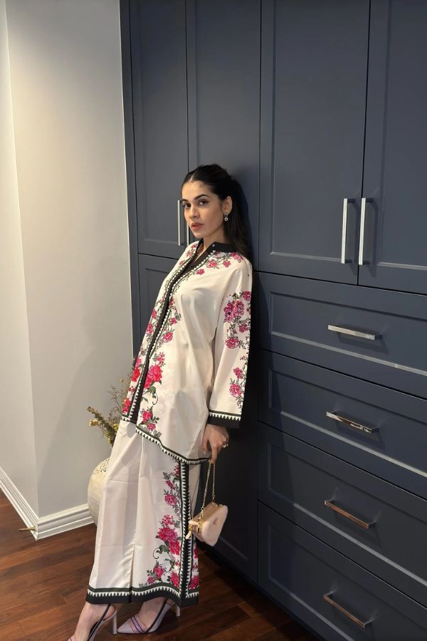 Woman in a floral outfit standing against a blue wardrobe.