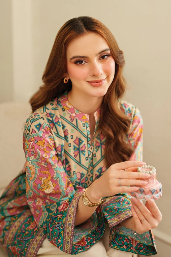 Woman wearing a colorful traditional outfit holding a glass of water.