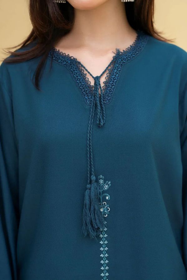 Teal blouse with lace detailing on a plain background