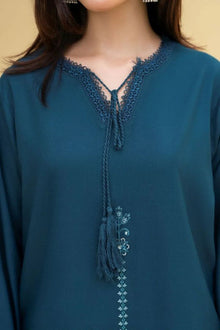 Teal blouse with lace detailing on a plain background