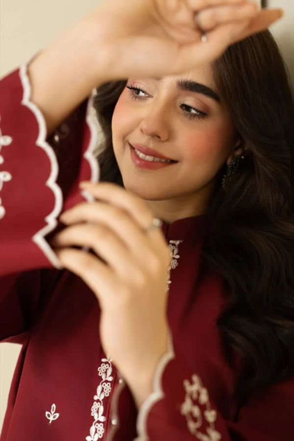 Woman holding a red embroidered fabric item