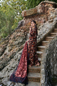Woman in a floral dress standing on stone steps with a natural background