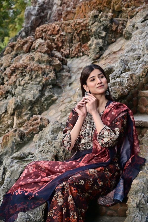 Woman in a traditional saree sitting on rocky steps outdoors