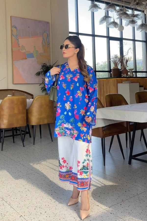 Woman in a colorful outfit standing in a modern restaurant.