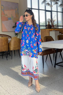 Woman in a colorful floral outfit standing in a modern restaurant setting