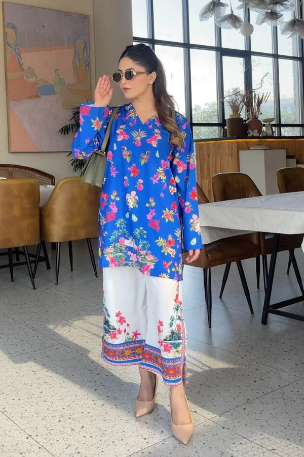 Woman in a colorful floral outfit standing in a modern restaurant setting