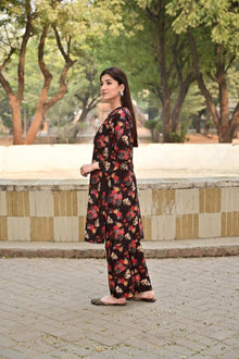 Woman in a floral dress standing outdoors with trees in the background