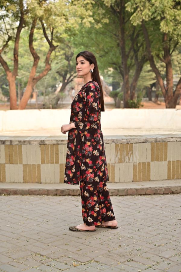 Woman in a floral dress standing outdoors with trees in the background