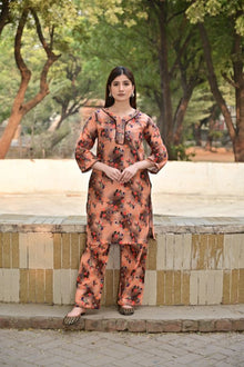 Woman in a floral outfit standing outdoors with trees in the background
