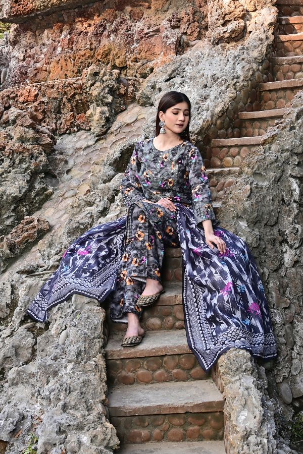 Woman in a floral dress sitting on stone steps with a natural rock background
