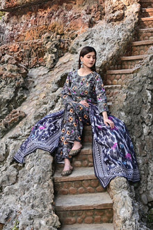 Woman in a floral dress sitting on stone steps with a natural rock background