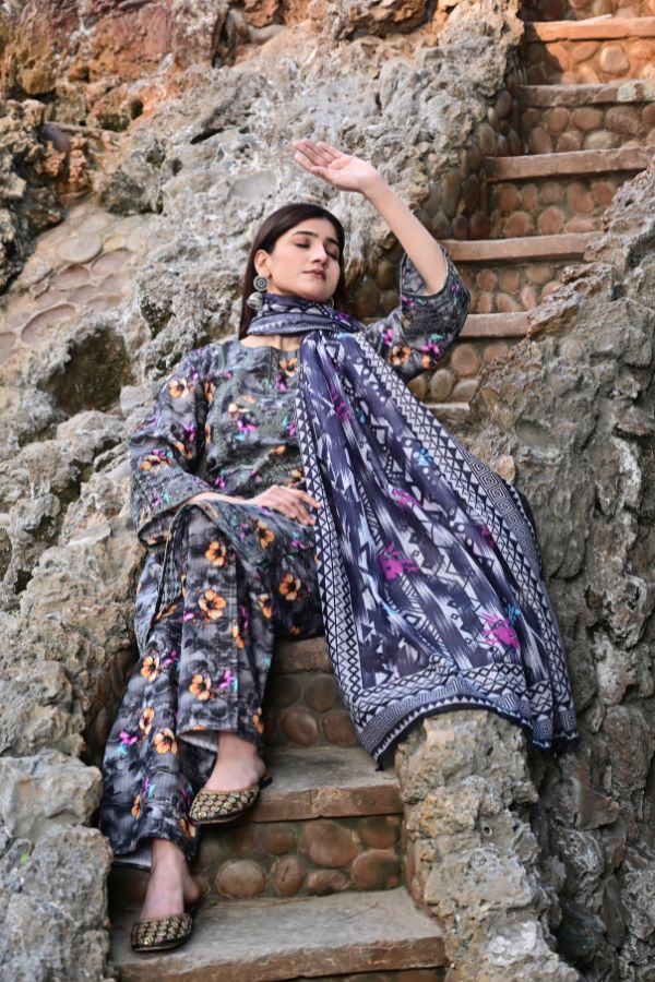 Woman in a floral outfit sitting on stone steps with a textured wall background