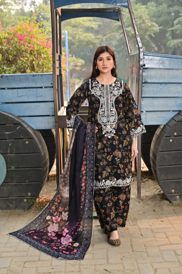 Woman in traditional outfit with floral design standing in front of a blue cart.