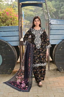 Woman in traditional outfit with floral design standing in front of a blue cart.
