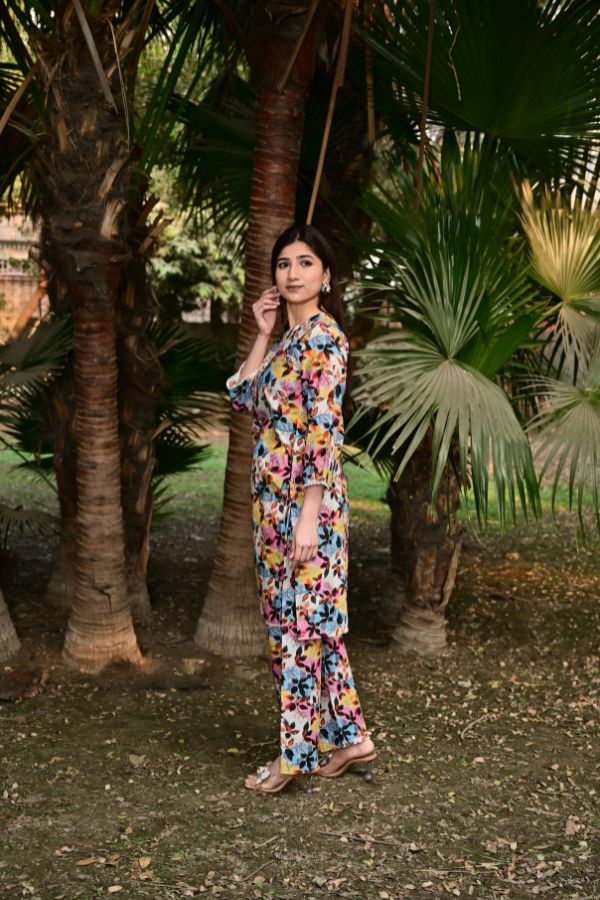 Woman in a floral outfit standing among palm trees