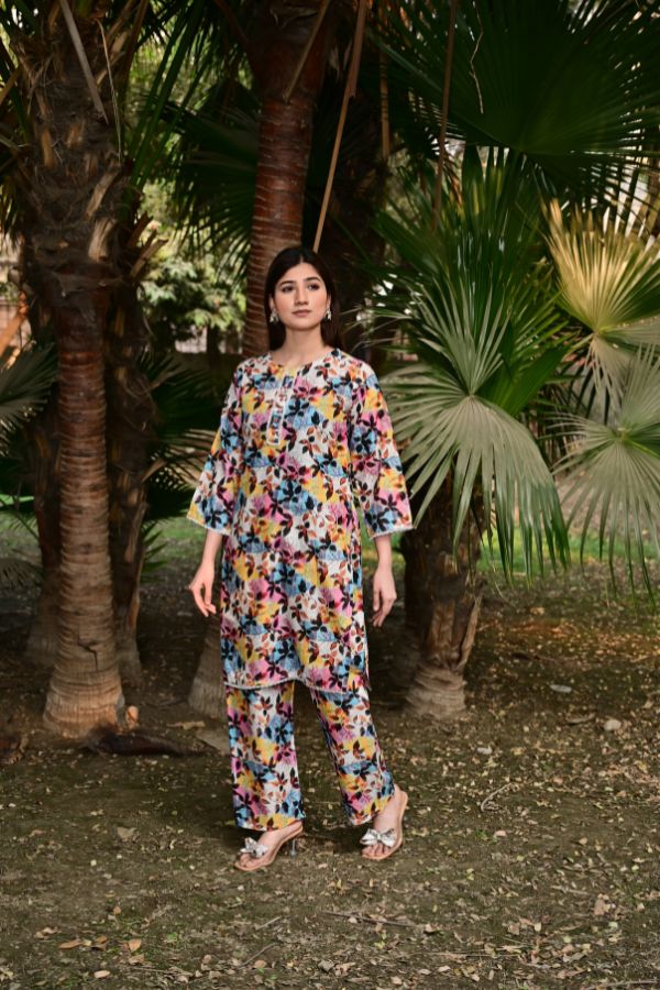 Woman in a floral outfit standing among palm trees