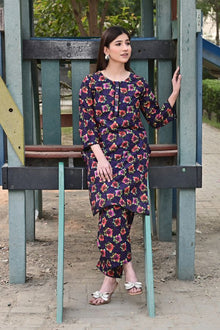 Woman in a floral dress standing on playground equipment